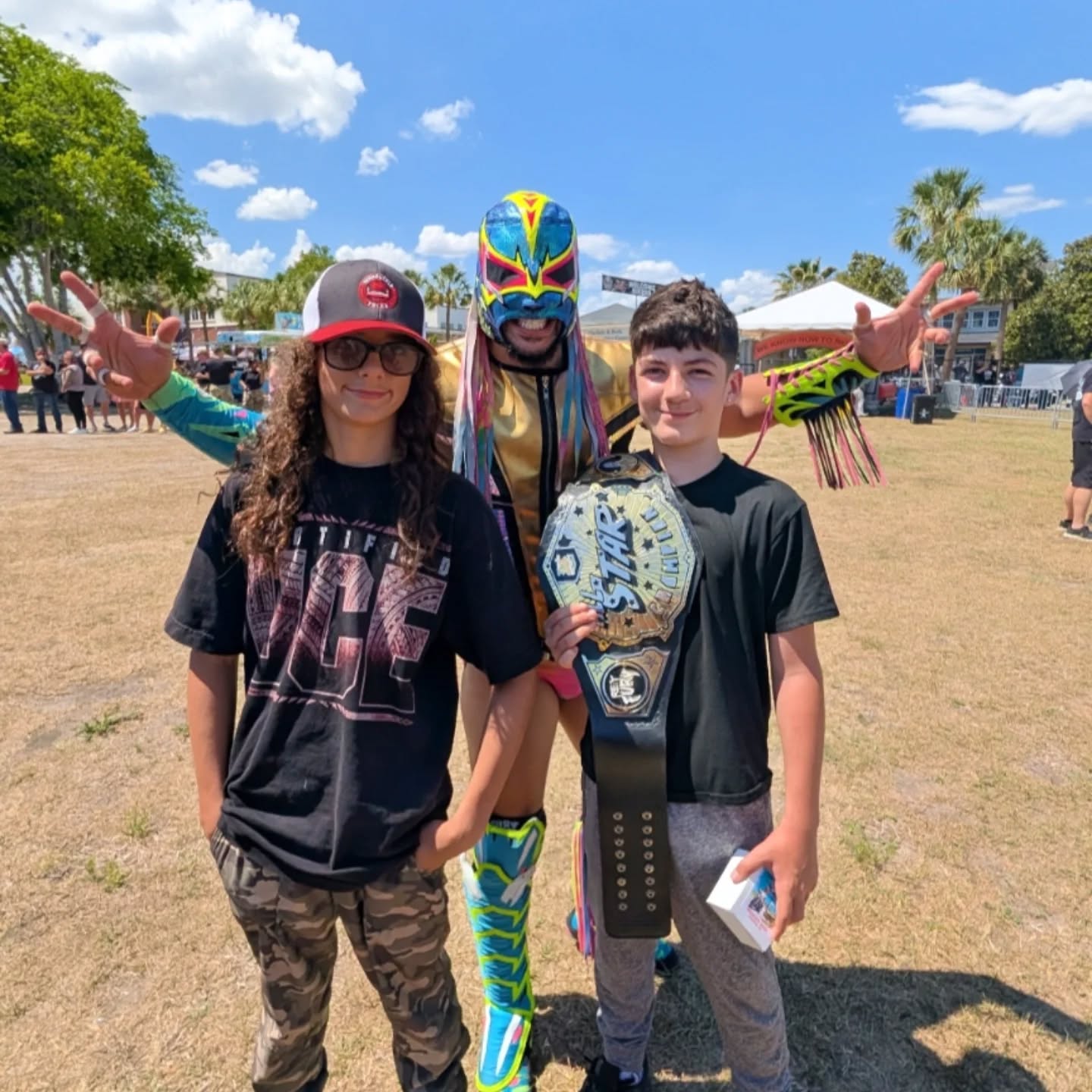 Trystan and a friend meet a masked champion at an outdoor wrestling event